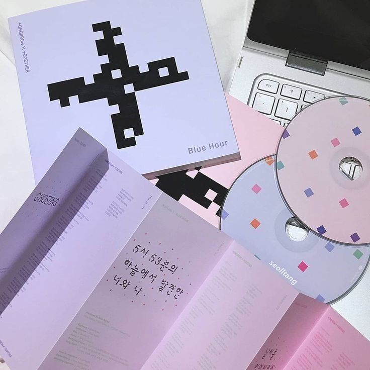 1 pink cd and 1 blue cd resting on a laptop keyboard along with txt blue hour album
