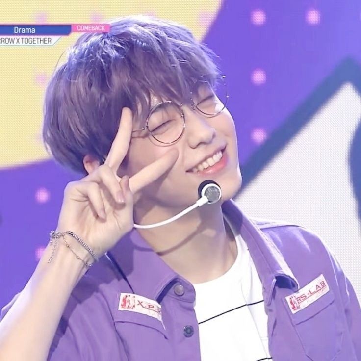 soobin of txt posing with peace sign, wearing a purple shirt and silver rimmed glasses
